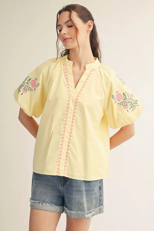 Short puff sleeves v neck woven top with  embroidery detail, notched v neck.