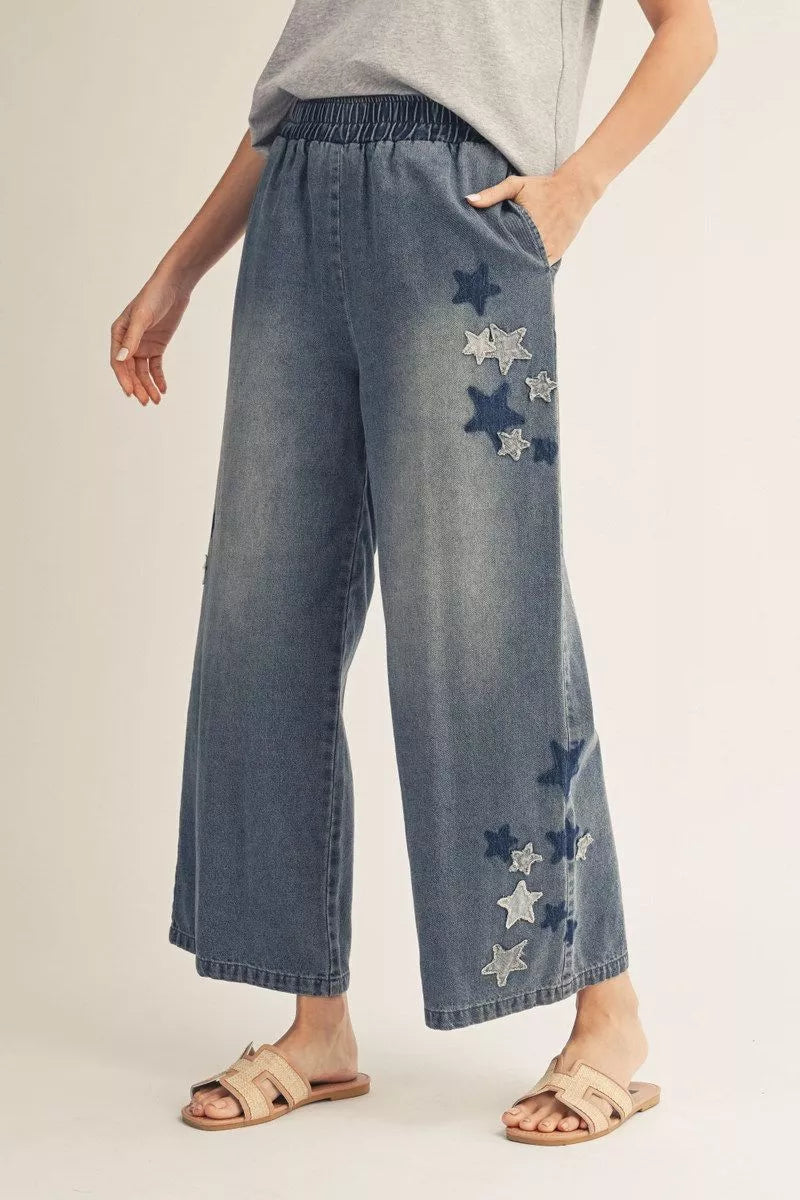 Elastic waist wide leg washed denim pants with star patch, side pockets.